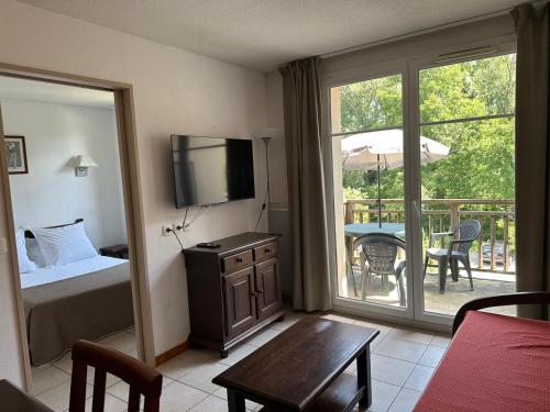 une chambre avec un lit et un balcon avec une table dans l'établissement Le Green, à Levernois