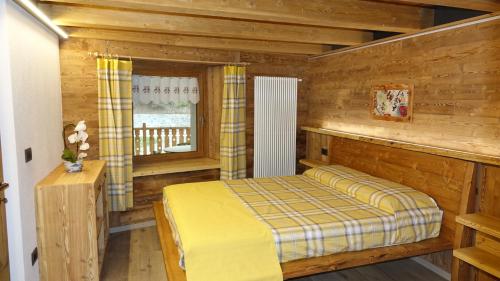 1 dormitorio con 1 cama en una cabaña de madera en Pila appartamenti La taverna Peroulaz, en Charvensod