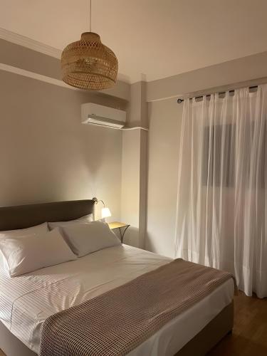 een witte slaapkamer met een bed en een raam bij Luxurious Apartment in the Heart of Athens in Athene