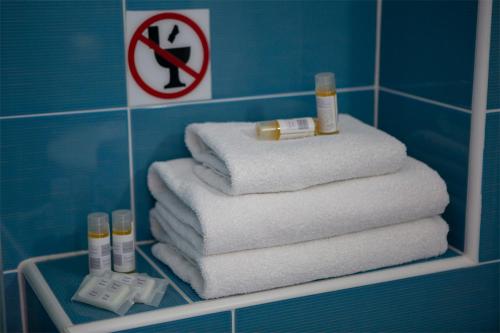 una pila de toallas en un estante del baño en Menes Hotel, en Yénion