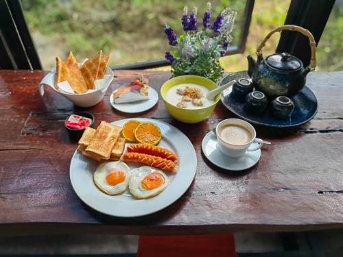 Phumaihom Resort في هات ياي: طاولة مع البيض والخبز المحمص وكوب من القهوة