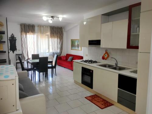 uma cozinha e sala de estar com um sofá vermelho em Nomentum House em Mentana