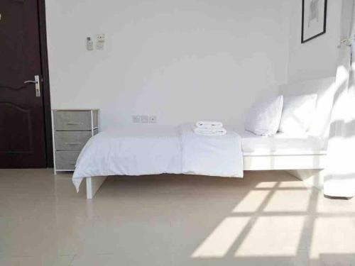 a white bedroom with a white bed and a dresser at Villa 9 Palms Beach in Ras al Khaimah
