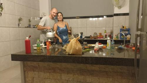 Un uomo e una donna in piedi in una cucina di Gending Sari House ad Ubud
