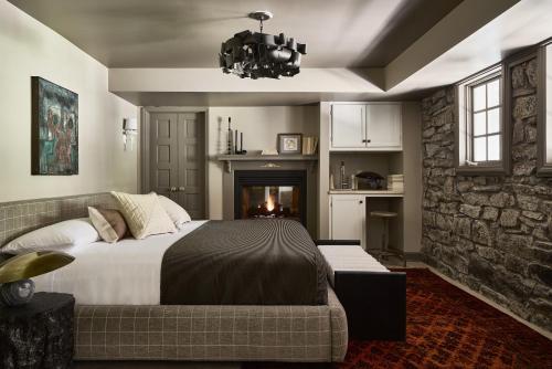 a bedroom with a bed and a couch and a fireplace at Blind Tiger Asheville in Asheville