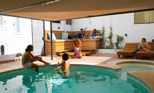 a group of people sitting around a swimming pool at Rafiki Hostels - Dahab in Dahab