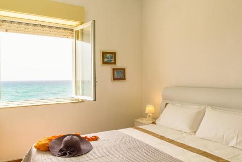 a bedroom with a bed with a hat on it at Sea paradise - il mare sotto la finestra in Riposto