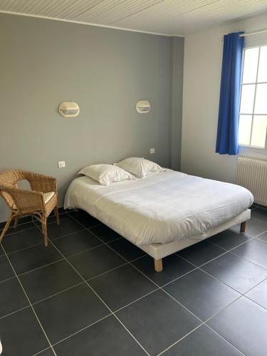 une chambre avec un lit et une chaise dedans dans l'établissement LE RELAIS DES HAYONS, à Esclavelles