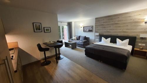 Habitación de hotel con cama y sofá en Spreewaldhof Romantik - Hotel Garni en Neu Zauche