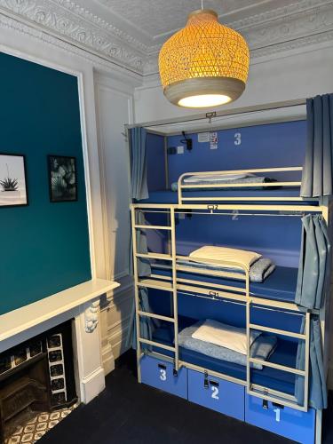 Camera con letti a castello blu e parete verde di Smart Hyde Park Inn Hostel a Londra