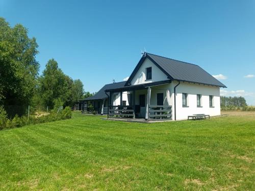 una gran casa blanca con un gran campo de césped en Domek letniskowy na Kaszubach, Borowy Młyn, jezioro Gwiazda, en Borowy Młyn