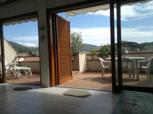 Cette chambre offre une vue sur un balcon doté d'une table et de chaises. dans l'établissement Porto Azzuro Apartment 6 Beds, à Porto Azzurro