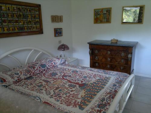 a bedroom with a bed and a dresser at Porto Azzuro Apartment 6 Beds in Porto Azzurro