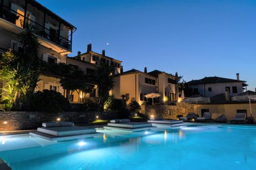 a swimming pool in front of a building at night at Agapitos Villas & Guesthouses in Agios Ioannis Pelio