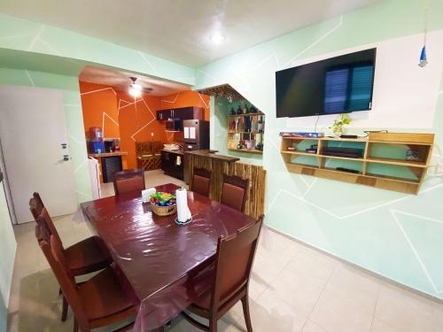 comedor con mesa, sillas y TV en Casa Mexicana Amplia con Seguridad, Alberca y Parking, en Playa del Carmen