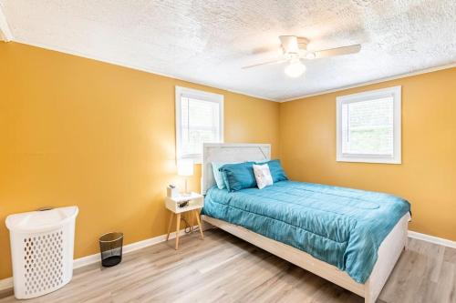 een slaapkamer met een bed en een gele muur bij Cozy, Private Beautiful, Cottage House. 