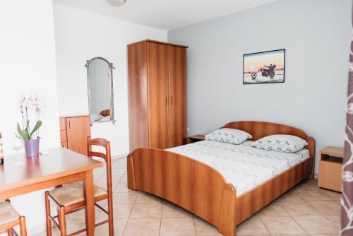 een slaapkamer met een bed, een tafel en een bureau bij Guest House Lalic in Bar