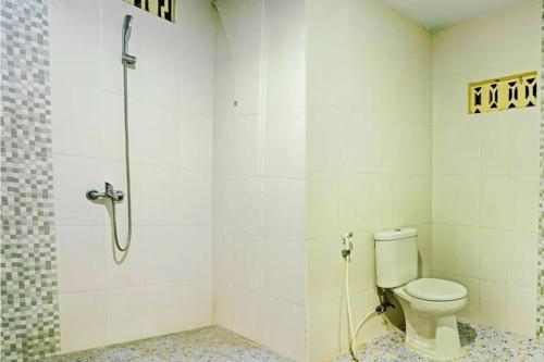 a bathroom with a toilet and a shower at Hotel Toba Shanda By Helocus in Parapat