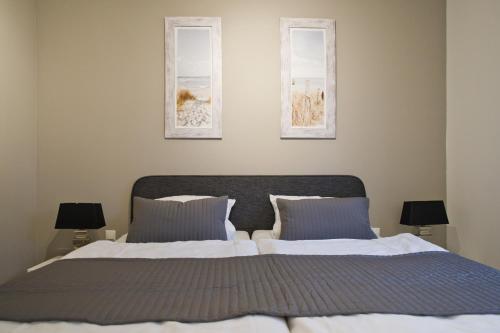 グレーミッツにある"Strandvilla Seagull - Whg Seaside"のベッドルーム1室(ベッド2台付)が備わります。壁に2枚の写真が飾られています。