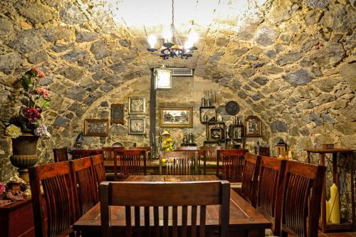 a restaurant with a table and chairs and a stone wall at RATAGS Kunsthandwerkerhaus in Langenwolmsdorf