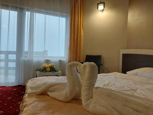 a towel animal laying on a bed in a hotel room at HOTEL CARMINA in Ranca