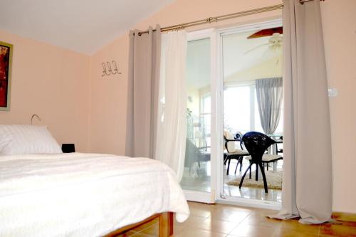 een slaapkamer met een bed en een glazen schuifdeur bij Wohnung mit Meerblick Romy in Preko