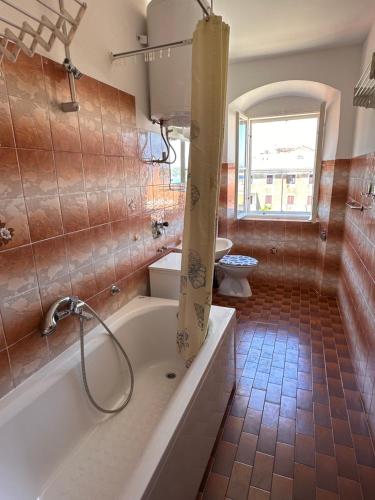 a bathroom with a tub with a shower and a toilet at UNA apartment in center of Mali Lošinj in Mali Lošinj