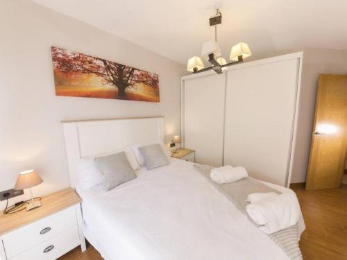 um quarto com uma cama branca e um quadro na parede em Jardines del Mar Salobreña by A3Rentals em Salobreña