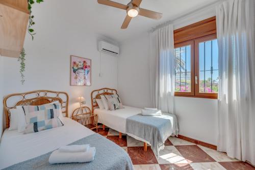 ein Schlafzimmer mit zwei Betten und einem Fenster in der Unterkunft VB Goya 7BR Andalusian Villa by the marina in Benalmádena