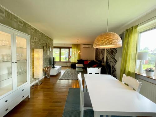 Centralt belägen villa i Öjebyn, Piteå في بيتيا: غرفة معيشة مع طاولة بيضاء كبيرة وكراسي