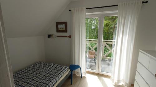 een slaapkamer met een bed en een groot raam bij Całoroczne domki Morska Laguna in Kopalino