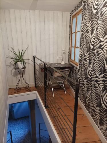 une chambre avec un escalier, une table et une plante dans l'établissement Charmante maison au coeur du Beaujolais, à Romanèche-Thorins