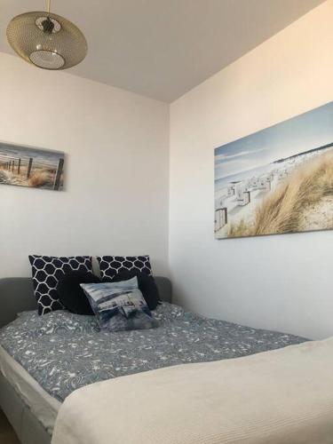 um quarto com uma cama e duas fotografias na parede em Apartament Nowy Port em Gdansk