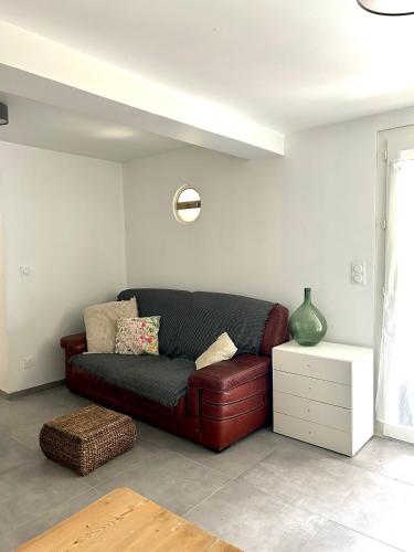 un salon avec un canapé marron et une table dans l'établissement Maison Thany 2, à Vals-les-Bains