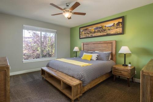 Un dormitorio con una cama con ventilador de techo y una ventana. en Entrada at Moab 652, en Moab