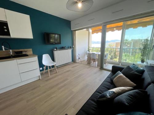 ein Wohnzimmer mit einem Sofa und eine Küche mit einem Tisch in der Unterkunft Pépite sur Cannes in Cannes