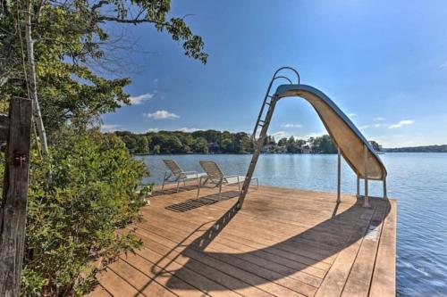 un muelle de madera con sillas y un tobogán sobre el agua en Fully accessible lake house on its own island, en Andover