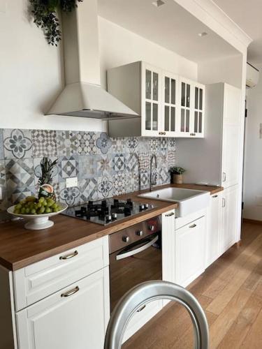 uma cozinha com armários brancos e uma taça de fruta em Appartamento incantevole centro Misano Adriatico em Misano Adriatico