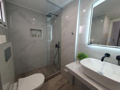 een badkamer met een douche, een wastafel en een toilet bij Eva Ivoni apartments in Amoudara Herakliou