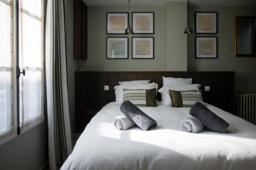 a bedroom with a white bed with pillows and a window at LeParticulier - L'Amiral in Chartres