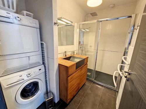 a bathroom with a washing machine and a shower at Appartement 4-6 couchages in Aulus-les-Bains