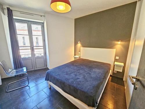 a bedroom with a large bed and a window at Appartement 4-6 couchages in Aulus-les-Bains