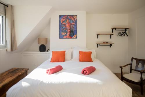 a bedroom with a large white bed with red pillows at LeParticulier - L'Amiral in Chartres