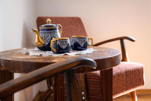 拉多夫利察的住宿－Art House Radovljica，桌子上放着两个杯子,茶壶