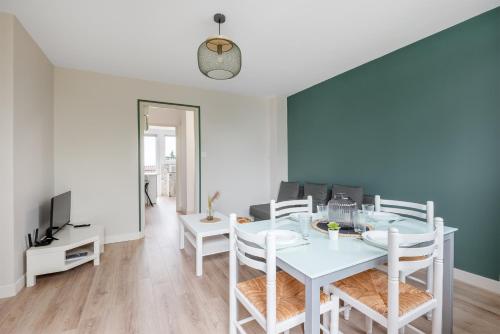 une salle à manger avec une table et des chaises blanches dans l'établissement T3 Centre Ville avec parking gratuit avec balcons, à Toulouse