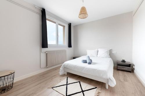 une chambre blanche avec un lit blanc et une fenêtre dans l'établissement T3 Centre Ville avec parking gratuit avec balcons, à Toulouse