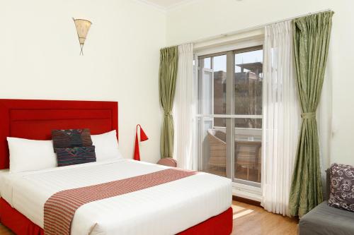 a bedroom with a large bed and a window at Shaligram Hotel in Pātan