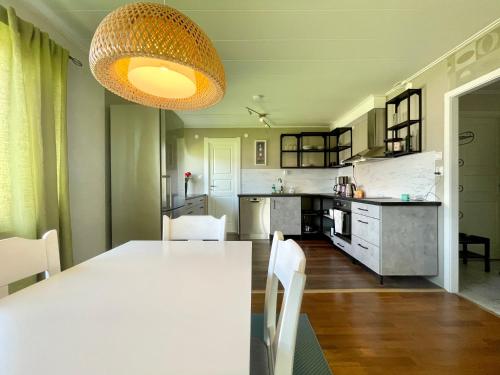 a kitchen with a white table and white chairs at Centralt belägen villa i Öjebyn, Piteå in Piteå