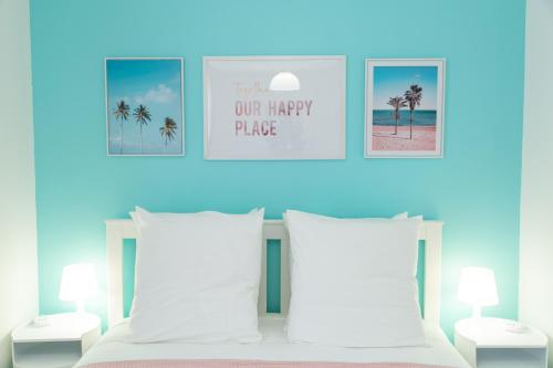 a bedroom with a bed with two pillows and palm trees at Le Florida proche aéroport CDG I Paris I Astérix in Moussy-le-Neuf