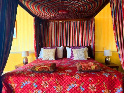 a bedroom with a large bed with a red comforter at The Falls - Value Rooms at Aultnagar Estate in Lairg